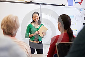 Teacher with tablet and students at an adult education class