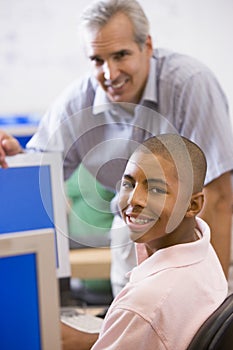 A teacher talks to a schoolboy using a computer