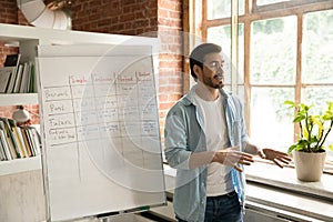 Teacher teach English while standing near flipchart with grammar tenses