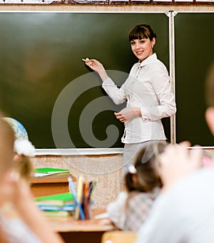 Teacher teaches students in classroom photo