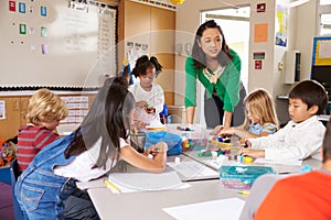 Teacher teaching elementary kids with block play in class