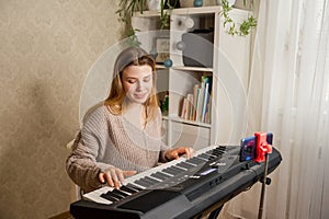 Teacher teaching her student to play piano and recording lesson online