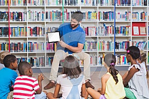 Teacher teaching kids on digital tablet in library