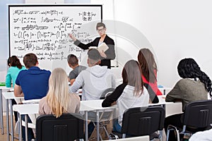 Teacher teaching math formulas to college students photo