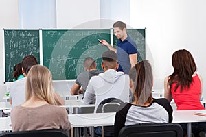 Teacher teaching mathematics to college students