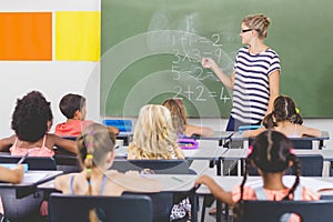 Teacher teaching mathematics to school kids in classroom photo