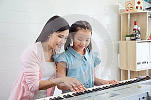 Teacher teaching student to play keyboard at school