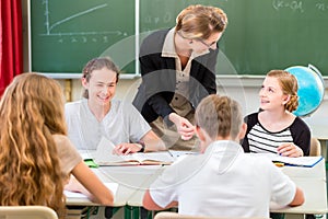 Teacher teaching students geography lessons in school