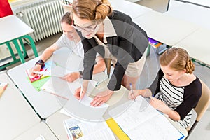 Teacher teaching students geography lessons in school