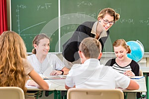 Teacher teaching students geography lessons in school