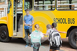 Teacher updating check list of kids while entering in bus