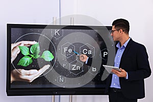 Teacher using interactive board in classroom during lesson