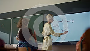 Teacher using interactive digital whiteboard. Student writing on smart board
