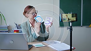 Teacher using mobile phone camera recording herself during learning online education course at school to prevent