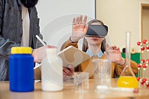 Teacher using Virtual Reality Glasses and 3D presentation to teach students in chemistry class. VR, Tutoring, New Technologies.