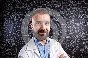 Teacher in white coat against big blackboard with mathematical s