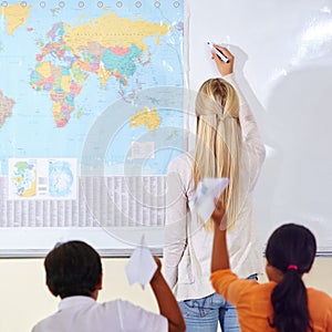 Teacher, woman and children in a classroom, learning and knowledge with information, paper planes and studying. Students