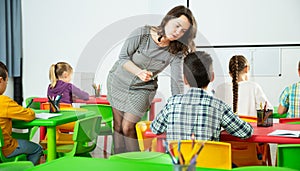 Teacher woman helping children during lesson