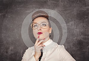 Teacher woman looking up above on the blackboard background