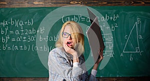 Teacher woman raising laptop above herself ready to destroy. Overstrain of the nervous system. Working conditions of