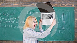 Teacher woman raising laptop above herself ready to destroy. Working conditions of teachers causes nervous disease. She