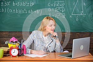 Teacher woman sit table work laptop surfing internet chalkboard background. Present lesson in comprehensive manner use