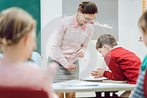 Teacher woman talking to student in class room