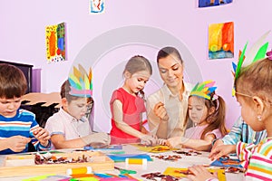 Teacher work with kids in art preschool class