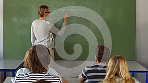 Teacher writing on blackboard in class