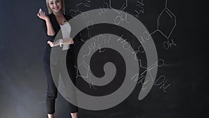 Teacher writing formulas on the chalk Board and explains the students the formula.