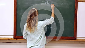 Teacher writing mathematics on board