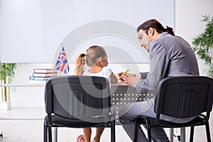 Teacher with young girl in the classroom