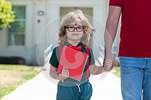 Teachers day. Portrait of happy nerd pupil holding teachers hand. School boy nerd going to school with father. Parent