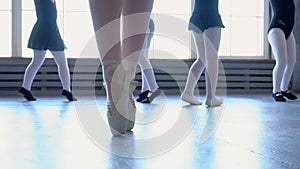 Teachers show how to dance to little ballerinas. Girl dancer in ballet school learns to dance. Young ballerinas jumping