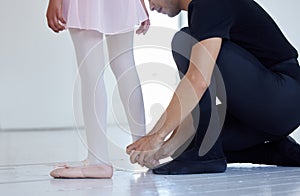 Teaching the correct steps and techniques. Closeup shot of a ballet teacher assisting a student with her position in a