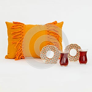 Teacups, plates, and a pillow on a white background and surface