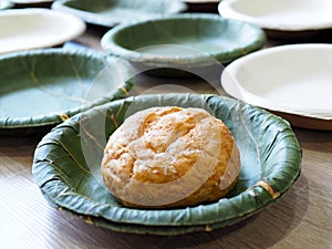 Teak , betel palm leaf dish plate organic pure green whole wheat bread bun nature natural selected focus