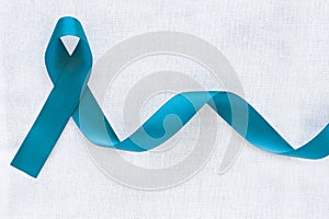 Teal color ribbon bow on white isolated background with copy space. Ovarian Cancer Awareness, Gynecological, Uterine Cancer, photo