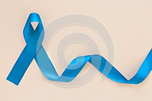 Teal color ribbon curl on white or beige isolated background, copy space. Ovarian Cancer Awareness, Gynecological, Uterine Cancer photo