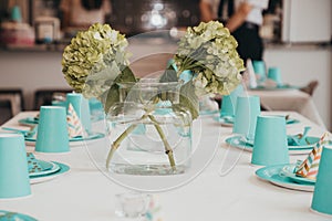 Teal cup plate and hat table Settings with a hydrangea centerpiece
