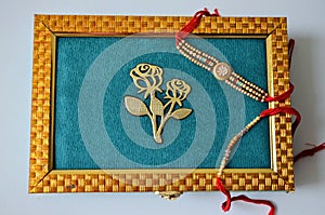 Teal and golden coloured dry fruit box with rakhis. white background. Hindu festival