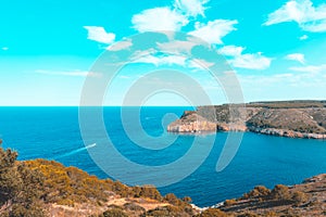 Teal and orange view of the small bay of Cala Montgo, costa brava, Spain