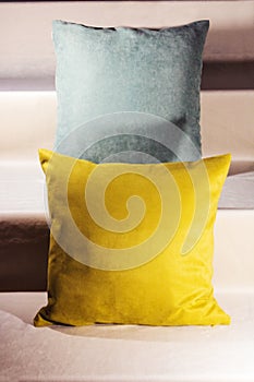 Teal and yellow pillows on velvet stairs