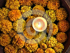 Tealight Candle Diya With Marigold Flower Floating in Water Inside Large Bowl. Happy Diwali - Hindu festival of lights