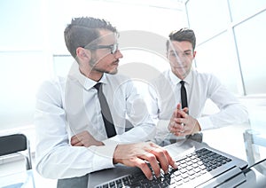 Team of 2 business people sitting and working on his laptop