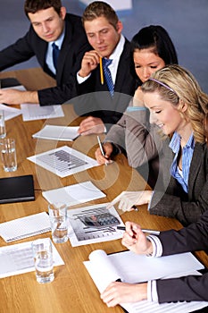 Team of 5 business people working on calculations photo