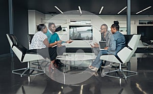 Team of african business people sitting in a modern office and talking during an work meeting