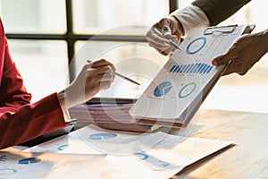 A team of analysts works on a financial data analysis dashboard on paper to use as market indicators