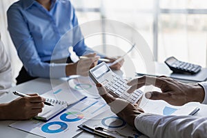 A team of analysts works on a financial data analysis dashboard on paper to use as market indicators