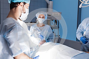 Team of anesthetists preparing patient for surgery at the operating room